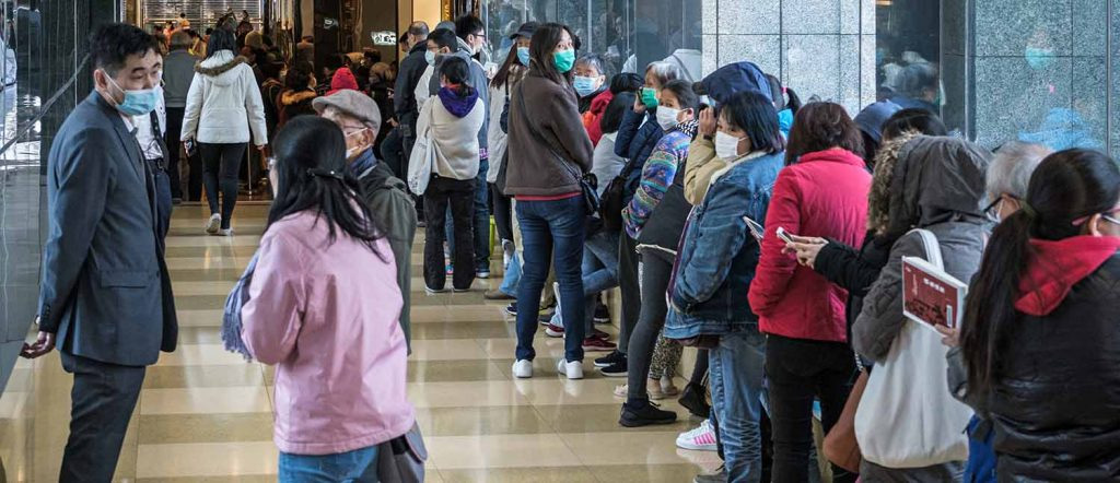 People in a long line wearing surgical masks