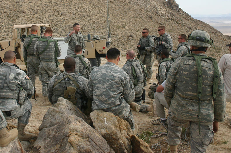 A training mentor at NTC conducts an after action review (AAR)