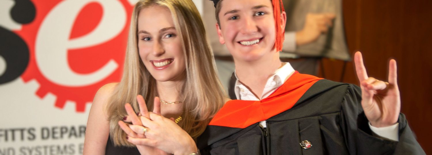 Fall 2021 ISE Graduation Ceremony with two students showing off their engagement ring