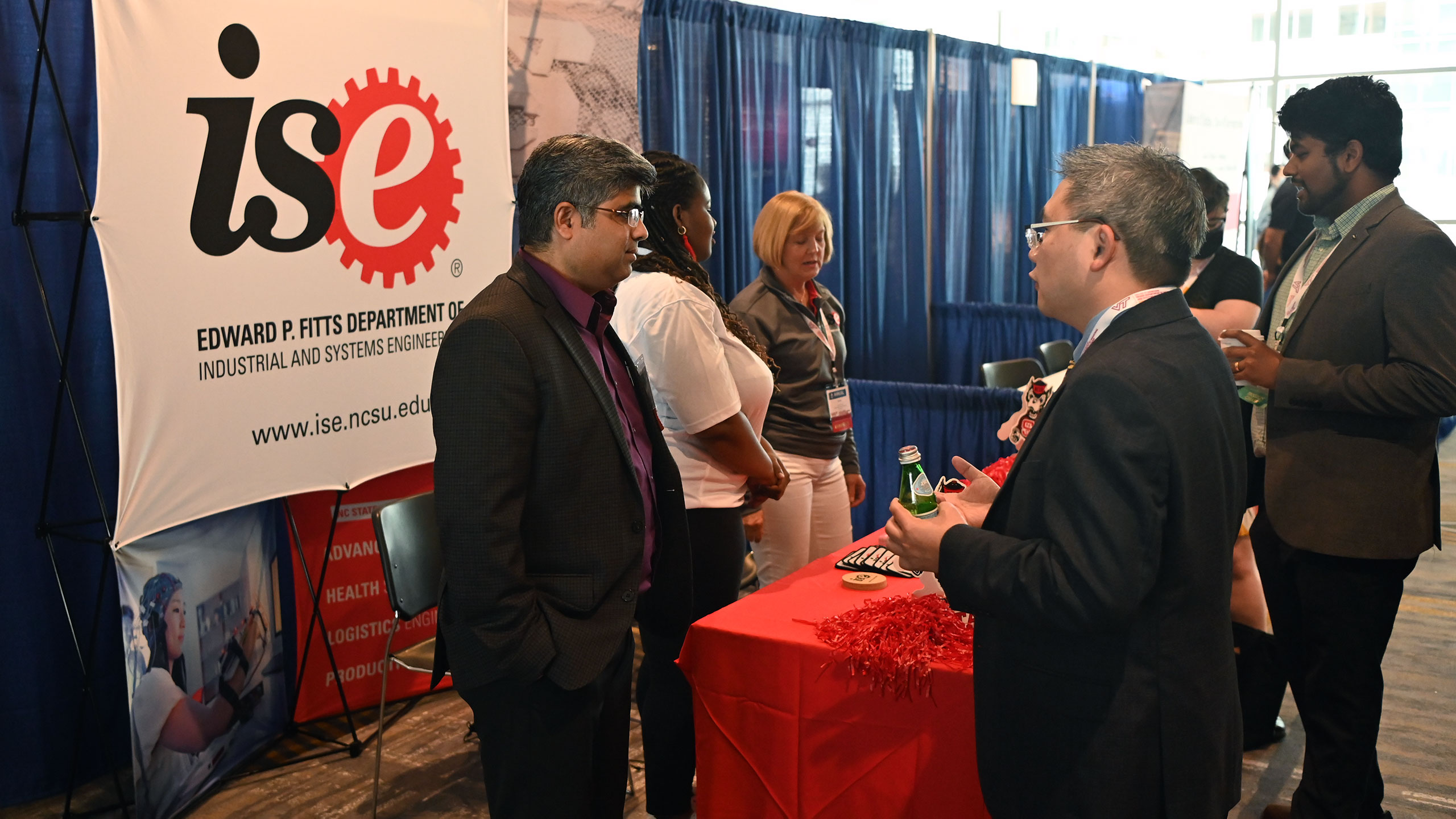 Rohan Shirwaiker talks with colleagues at the ISE conference booth