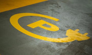 An EV charging station icon painted on the ground