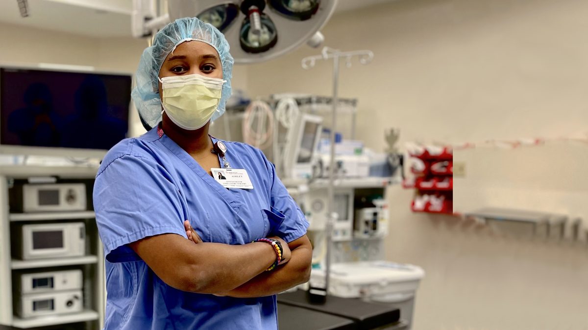 Ashley Eli with her arms crossed in an operating theater.