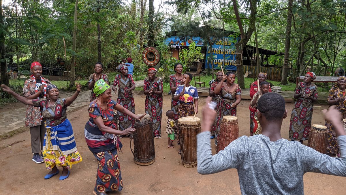  Rwandan women who are part of the Red Rocks cultural center cooperative pictured dancing and subsequently encouraging students to join them.