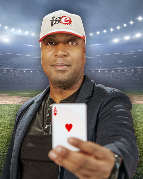 Fred Livingston holding a ace card. in front of a stadium.
