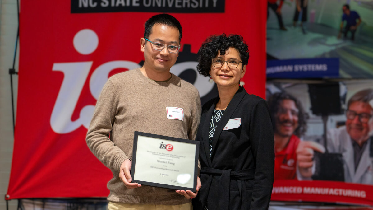 Xiaolei Fang receiving an ISE Outstanding Research Award.